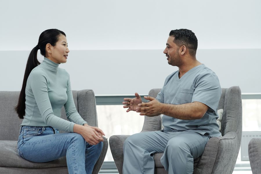 A doctor in scrubs talking with a patient