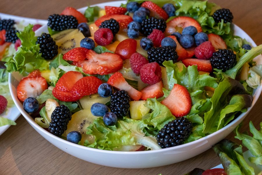 A bowl of fresh fruit and salad leaves